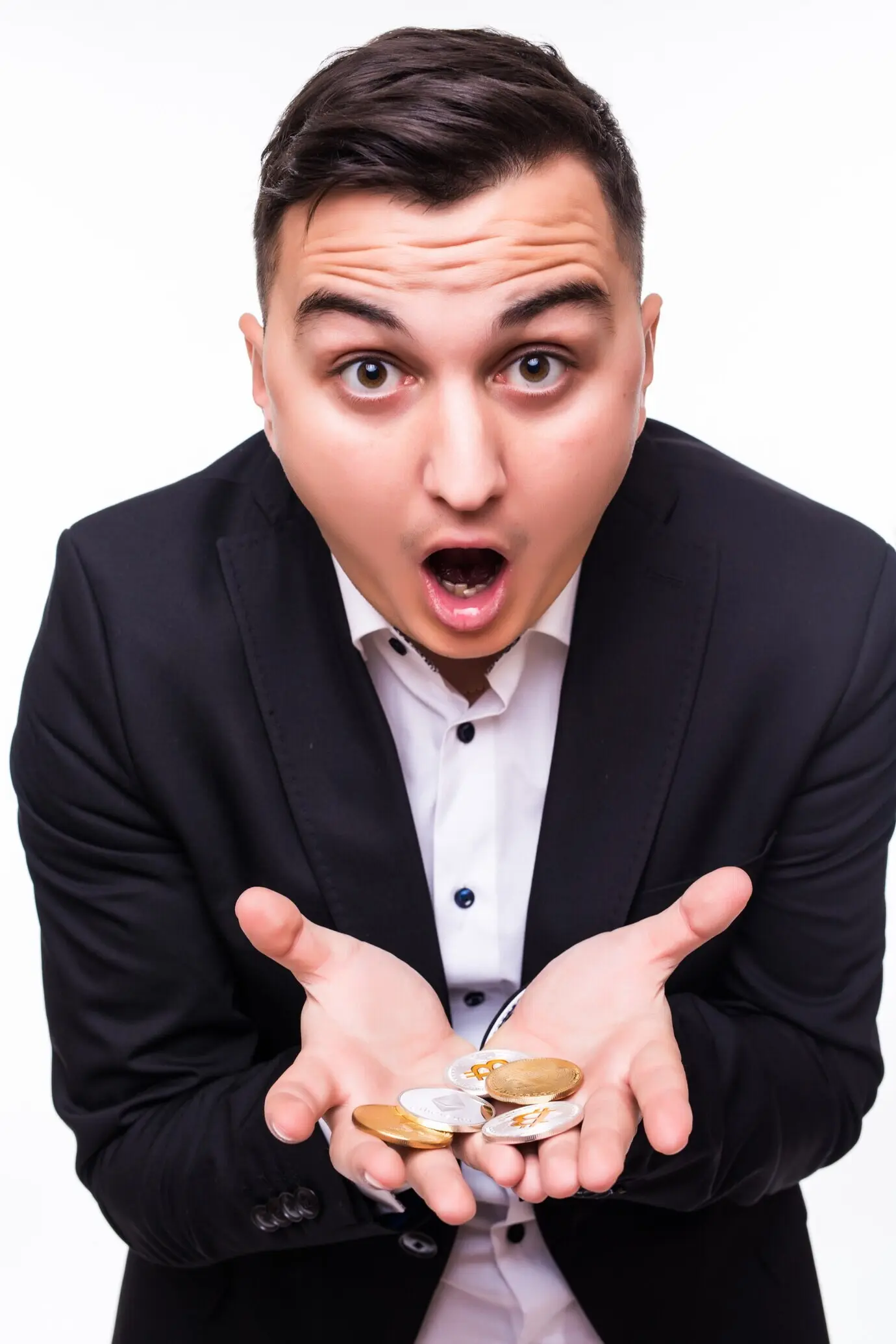 Ein Junge hält verschiedene Krypto-Coins in seinen Händen vor weißem Hintergrund.